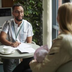 Two people sitting at a table with paperwork potentially reviewing unclaimed benefits, entitlement, and energy or utility bills