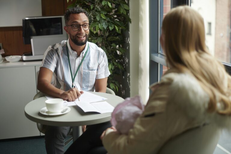 Two people sitting at a table with paperwork potentially reviewing unclaimed benefits, entitlement, and energy or utility bills
